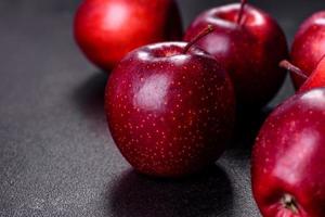 deliziose mele fresche in rosso su uno sfondo di cemento scuro foto