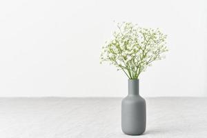 fiori di gipsofila in un vaso. luce soffusa, minimalismo scandinavo, foto