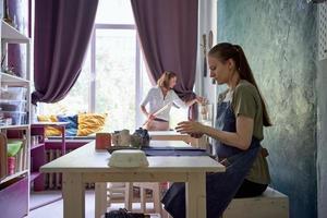 master class sulla fabbricazione di utensili di argilla, una donna insegna all'altra foto