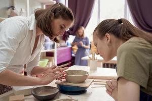 seminario sulla formazione in ceramica, una donna insegna a un'altra foto