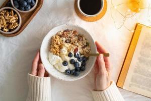 libro con vista dall'alto e colazione natalizia con uno stile di vita sano con muesli di muesli e yogurt foto