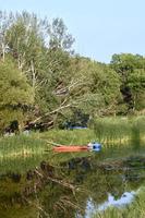 una canoa rossa si trova sulla riva di un fiume foto