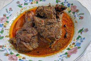 carne di manzo indonesiana rendang servita nel piatto foto