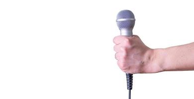 mano femminile con microfono, su sfondo bianco. foto