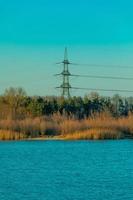 rete elettrica che raggiunge la foresta dal lago blu foto