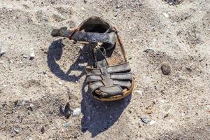 vecchia scarpa vintage su una spiaggia sabbiosa. foto