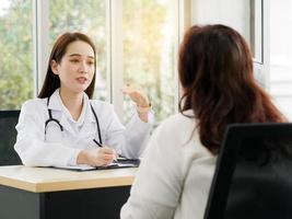 una dottoressa o un'infermiera sta parlando o intervistando una paziente di mezza età, idee per concetti sanitari. foto