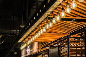 luce della lampada del cerchio di tungsteno sulla fila, bastone sul soffitto del chiosco di legno. foto