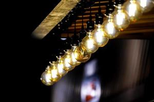 luce della lampada del cerchio di tungsteno sulla fila, bastone sul soffitto del chiosco di legno. foto