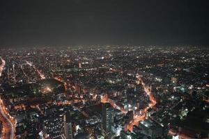 connessione di rete con cerchio di luce al neon e vuoto all'interno per eventuali loghi o icone aziendali., in alto edificio sullo sfondo di notte. foto