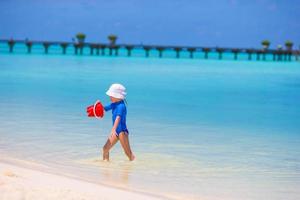 adorabile bambina che gioca con i giocattoli da spiaggia durante le vacanze tropicali foto