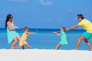 famiglia felice che gioca insieme sulla spiaggia bianca foto