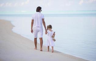 papà e bambina con peluche durante le vacanze estive foto