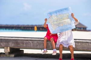 adorabili bambine con la mappa dell'isola sulla spiaggia foto