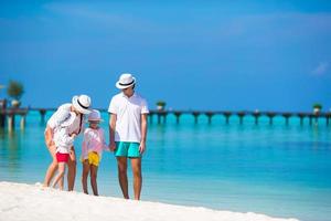 famiglia felice sulla spiaggia bianca durante le vacanze estive foto