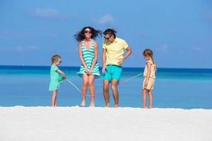 famiglia felice che gioca insieme sulla spiaggia bianca foto