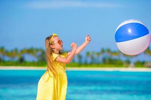 bambina adorabile che gioca sulla spiaggia con la palla foto