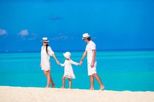 famiglia felice sulla spiaggia bianca alle Maldive foto