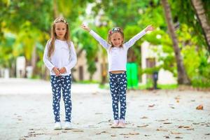 adorabili bambine che si divertono durante le vacanze al mare foto