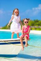 adorabili bambine che si divertono durante le vacanze al mare foto
