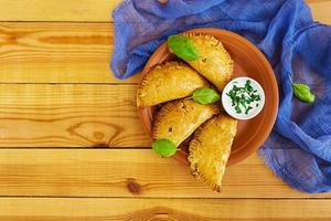 empanadas al forno su fondo di legno. vista dall'alto foto