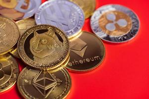 dogecoin doge group incluso con criptovaluta coin bitcoin, ethereum eth, ripple coin xrp, ethereum classic ecc. simbolo tecnologia blockchain virtuale il futuro è la perdita di denaro da vicino su sfondo rosso foto