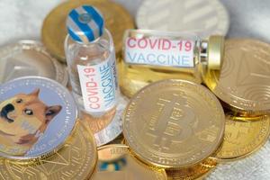 ampolle vaccino covid 19 coronavirus su gruppo di dogecoin doge incluso con moneta criptovaluta bitcoin, ethereum eth, simbolo della moneta binance tecnologia blockchain virtuale il futuro è il concetto di denaro. foto
