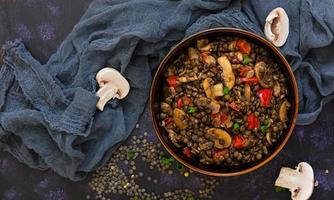 deliziose lenticchie con pepe e funghi su sfondo scuro foto