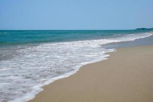 Colpo grandangolare dell'acqua di mare che colpisce la spiaggia, spugna bianca del mare, concetto di immagine di sfondo della natura estiva. foto