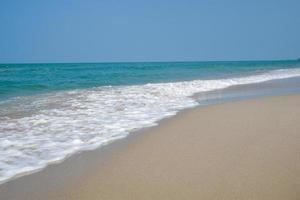 Colpo grandangolare dell'acqua di mare che colpisce la spiaggia, spugna bianca del mare, concetto di immagine di sfondo della natura estiva. foto