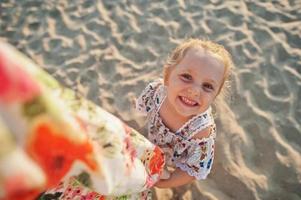 figlia che si diverte sulla spiaggia. ritratto di felice bambina carina in vacanza. foto