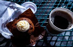 colazione all'aperto con caffè nero e muffin foto