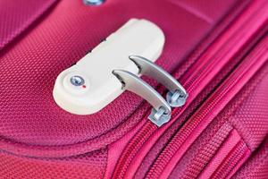 serratura a combinazione sulla borsa da viaggio valigia rossa foto