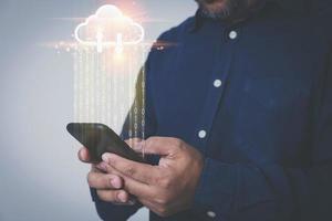 l'uomo d'affari utilizza uno smartphone per trasferire le informazioni sui dati, caricare o scaricare il database con il cloud computing virtuale e con spazio di copia. concetto di database di trasformazione tecnologica. foto