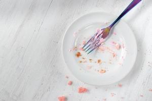 piatto vuoto di briciole di torta di compleanno con forchetta piatta foto