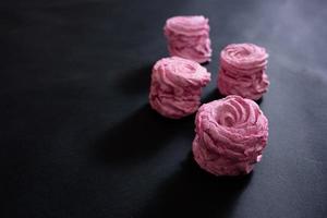 marshmallow rosa fatto in casa su sfondo nero. vista dall'alto foto