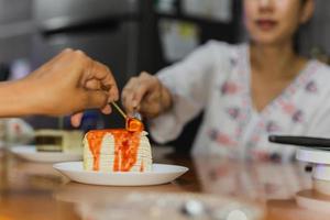 la mano felice della famiglia con il cucchiaio si diverte a mangiare la torta di crespo a casa. foto