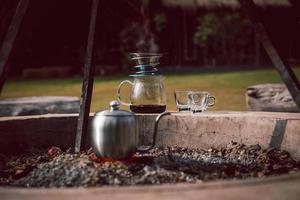 caffè gocciolante all'aperto nel parco naturale con bollitore sull'impostazione del falò. foto