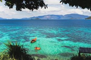 bellissimo paesaggio estivo dell'isola tropicale con barca a coda lunga nell'oceano. foto