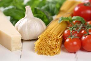 ingredienti per un pasto di spaghetti pasta pasta con pomodori, basilico foto