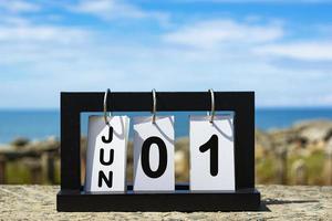 01 giugno testo della data del calendario su cornice di legno con sfondo sfocato dell'oceano foto
