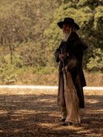 il cowboy anziano ha un lungo fucile di guardia per cercare la sicurezza foto