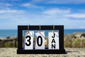 30 gen calendario data testo su telaio in legno con sfondo sfocato dell'oceano. foto