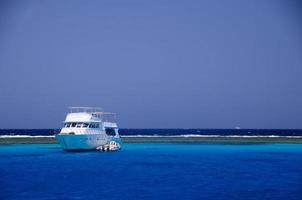 nave sulla barriera corallina nel mare blu profondo foto