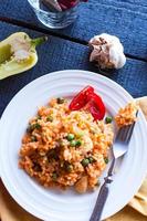 risotto con pollo e verdure su un piatto con forchetta foto