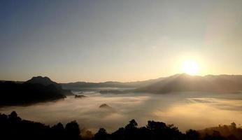 l'alba e la montagna si ricoprono di nebbia foto