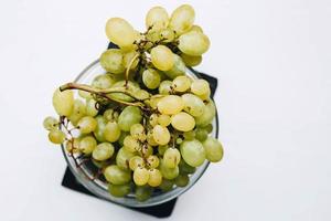 vista dall'alto di uve fresche in una ciotola su sfondo bianco foto