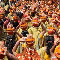 donne con kalash sulla testa durante il tempio di jagannath mangal kalash yatra, devoti indù indiani portano pentole di terracotta contenenti acqua sacra con una noce di cocco in cima foto