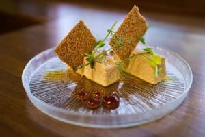 piatto di foie micuit con crostini croccanti e gocce di marmellata.