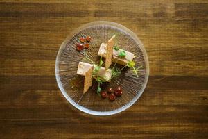 vista dall'alto del piatto di foie micuit con crostini croccanti e gocce di marmellata. foto